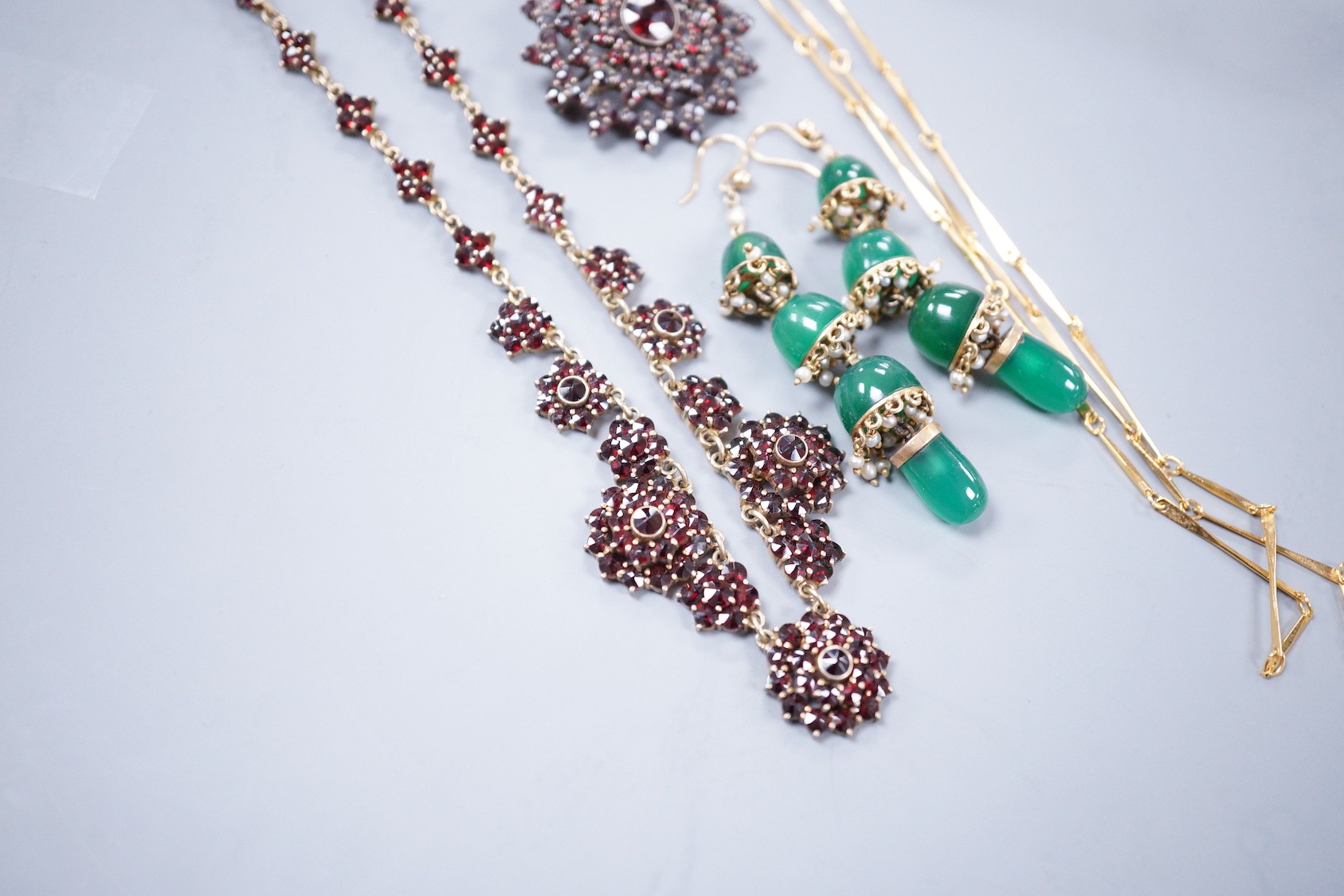 A Victorian gilt white metal and facetted garnet cluster set necklace, 42cm, a similar brooch, a pair of chrysoprase set drop earrings and a gilt metal necklace.